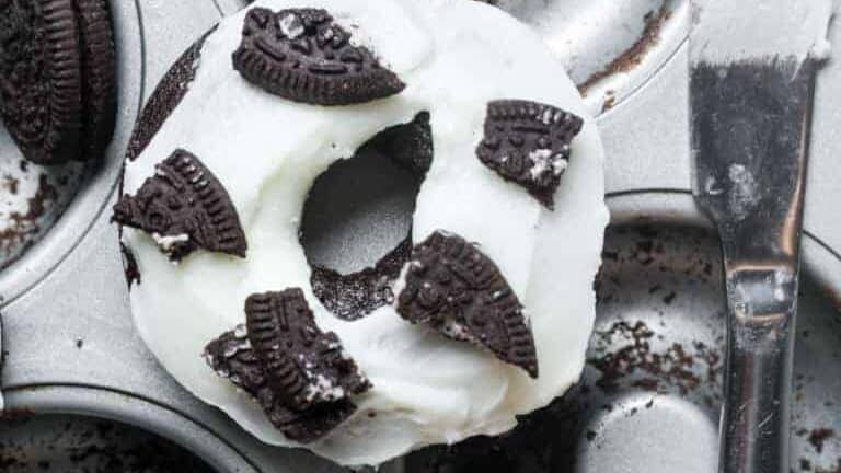 A muffin tin with cookies and cream on top.