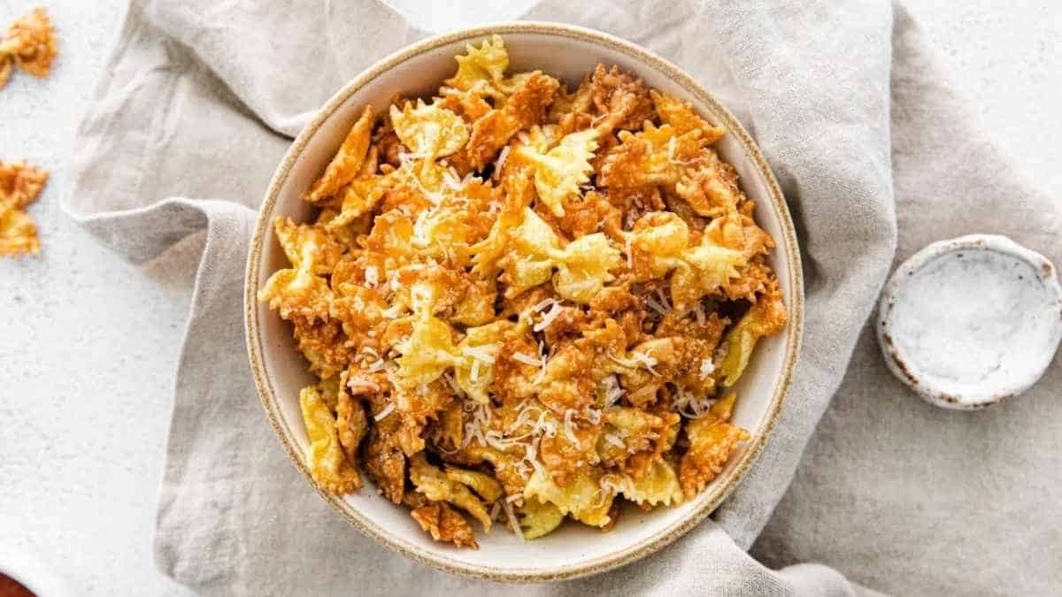 A bowl of pasta topped with parmesan cheese.