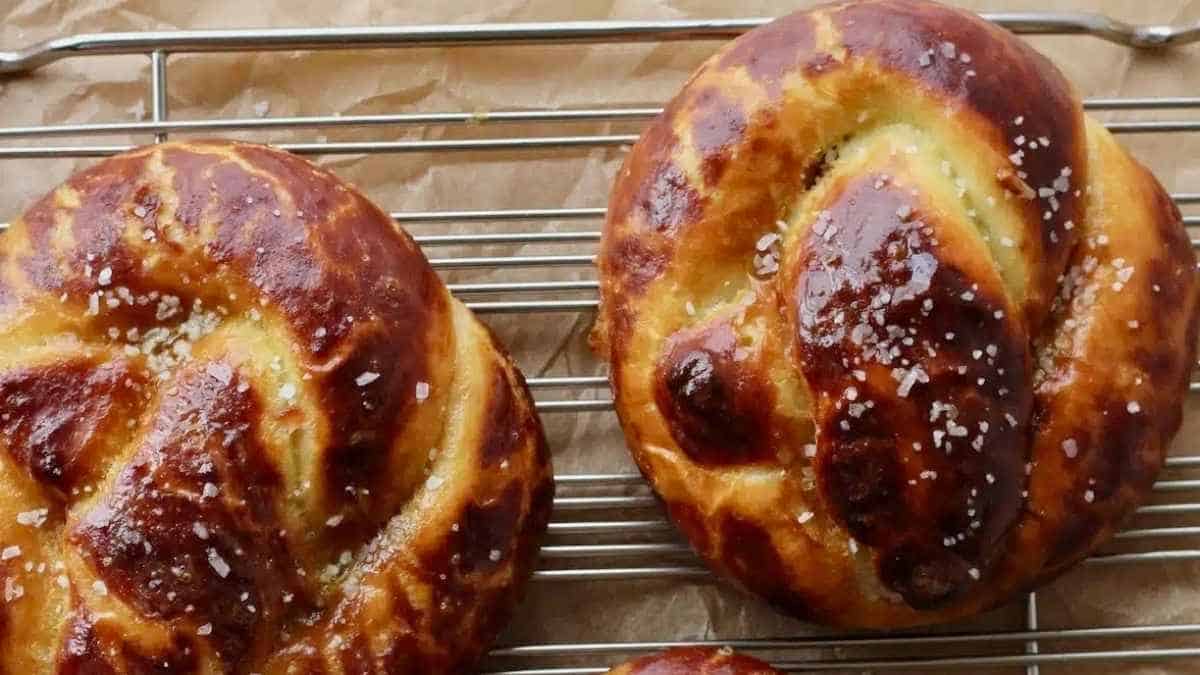 Two pretzels sitting on a cooling rack.