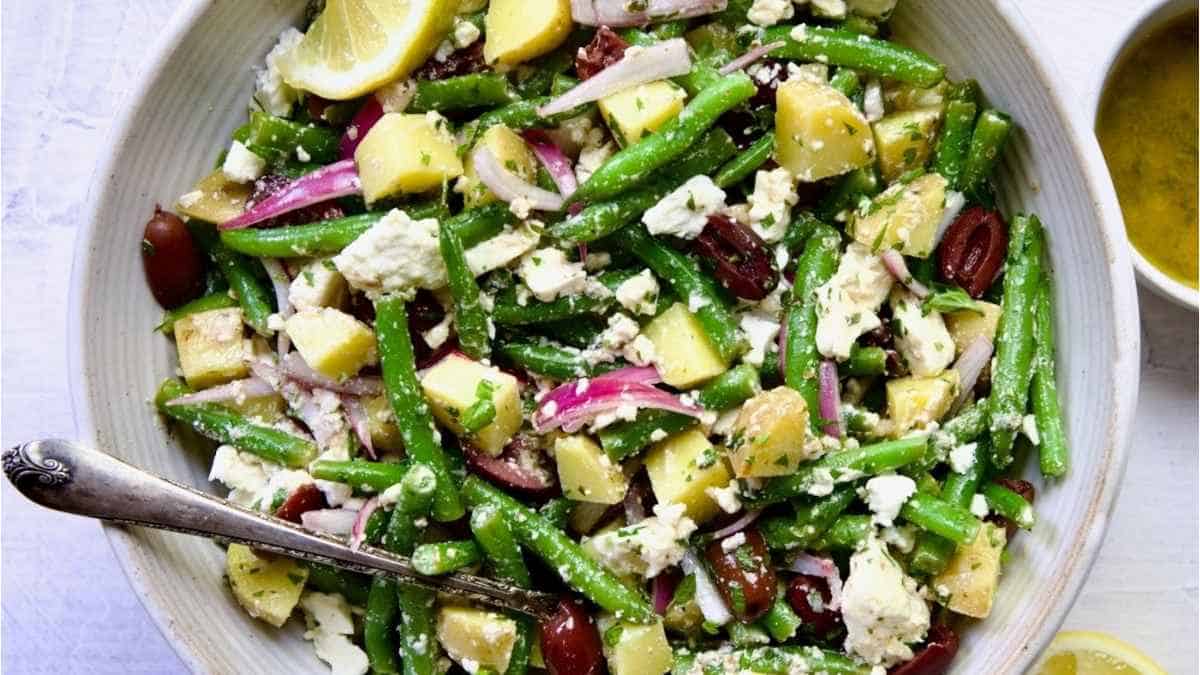 Green bean salad in a bowl with lemon and olives.