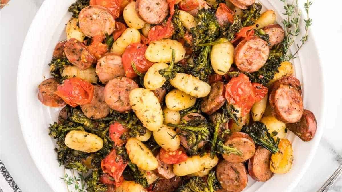 Roasted potatoes, sausage and brussels sprouts on a white plate.