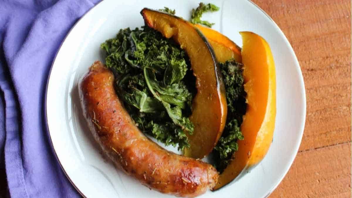 A plate with sausage and kale on it.