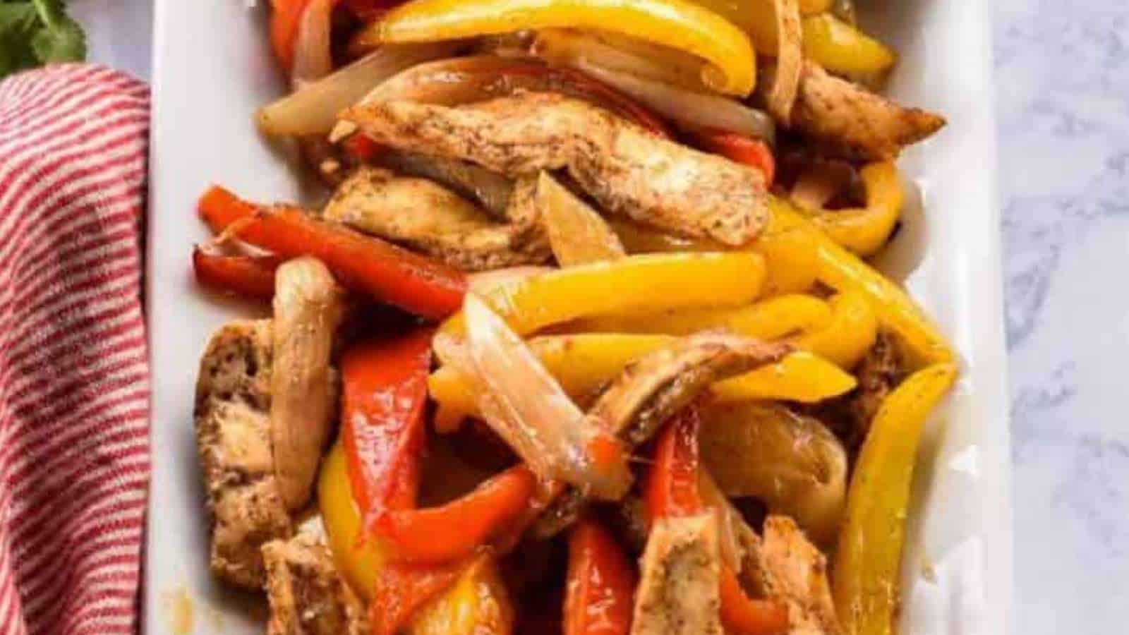 Chicken and peppers on a white plate.
