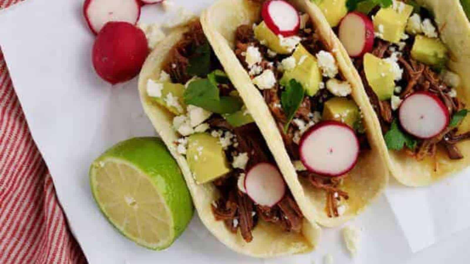 Pulled pork tacos with radishes and limes.