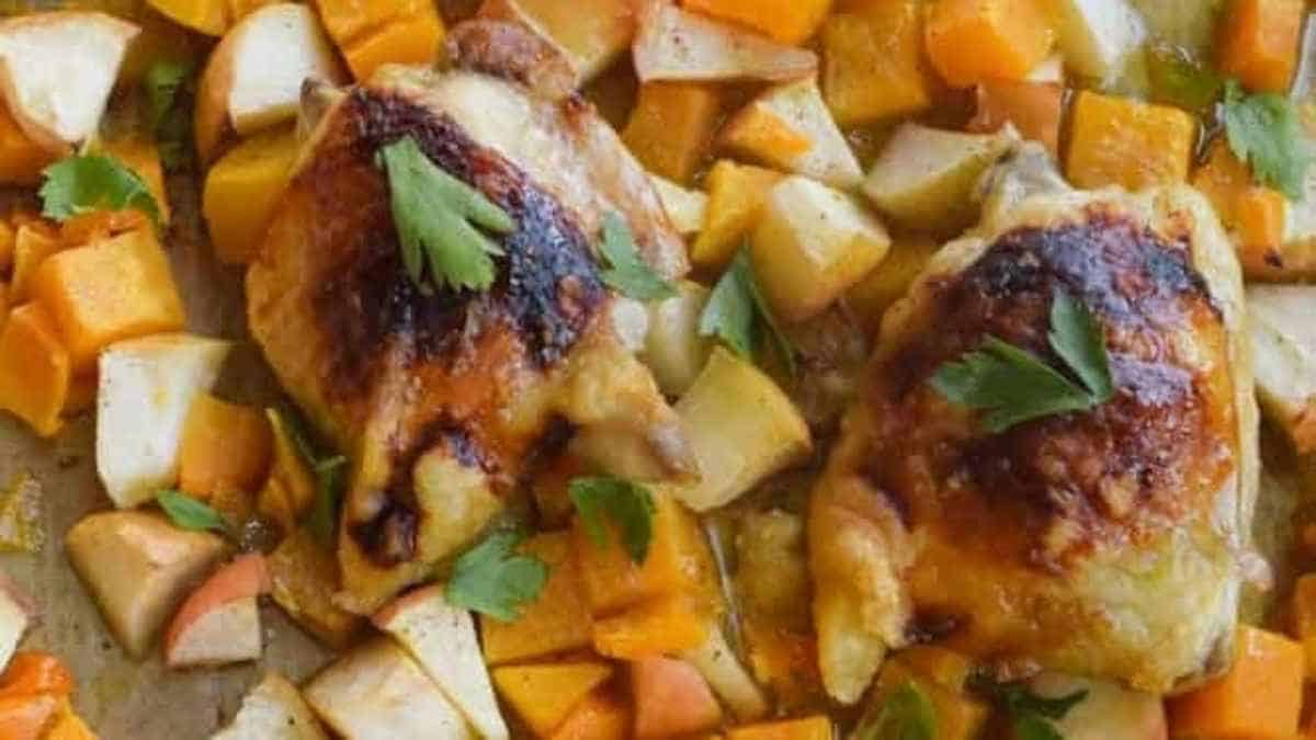 Roasted chicken and sweet potatoes on a baking sheet.