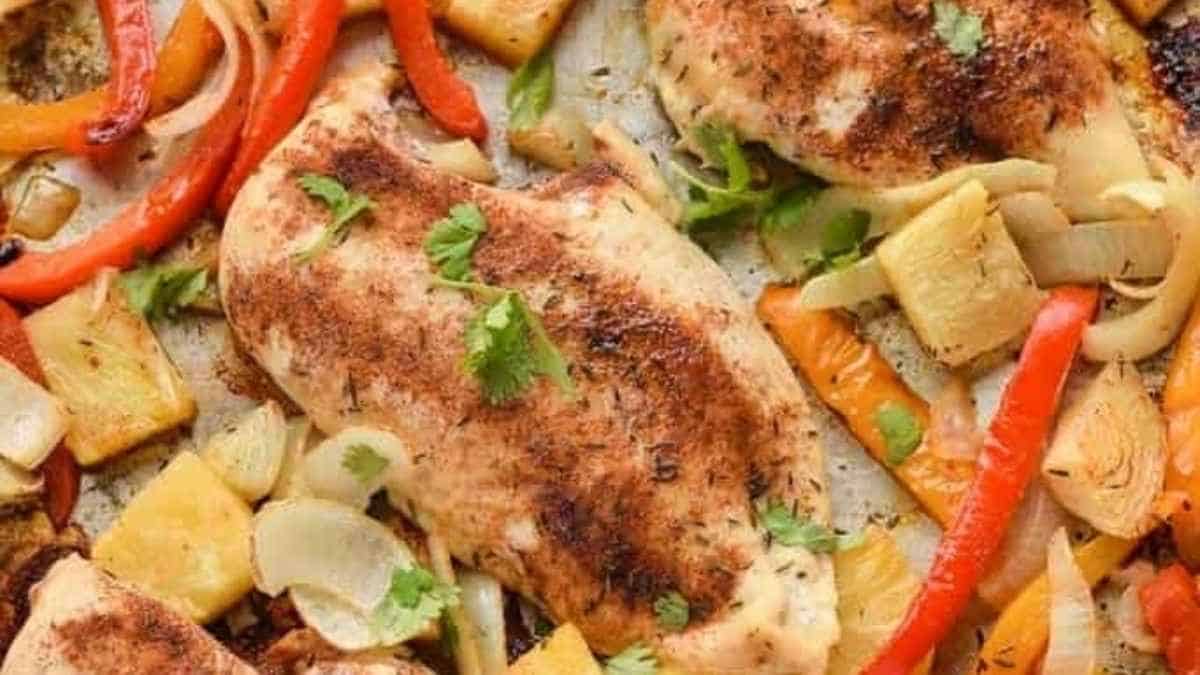 Chicken breasts and vegetables on a baking sheet.