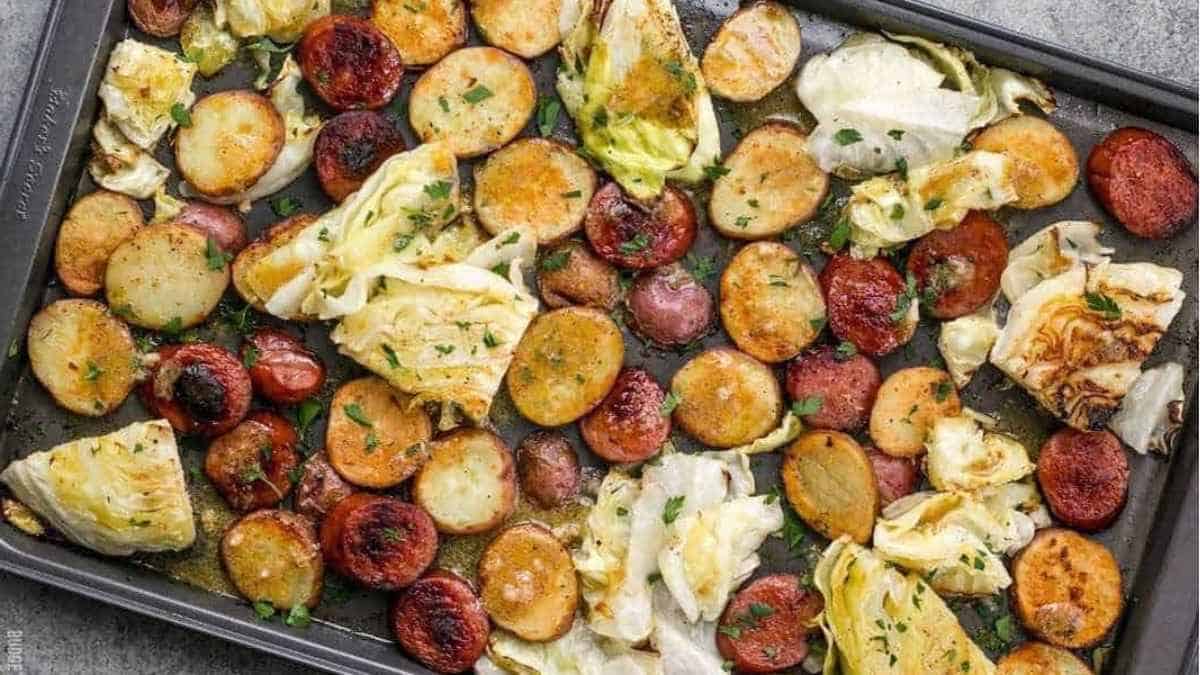 A baking sheet full of roasted potatoes and sausages.