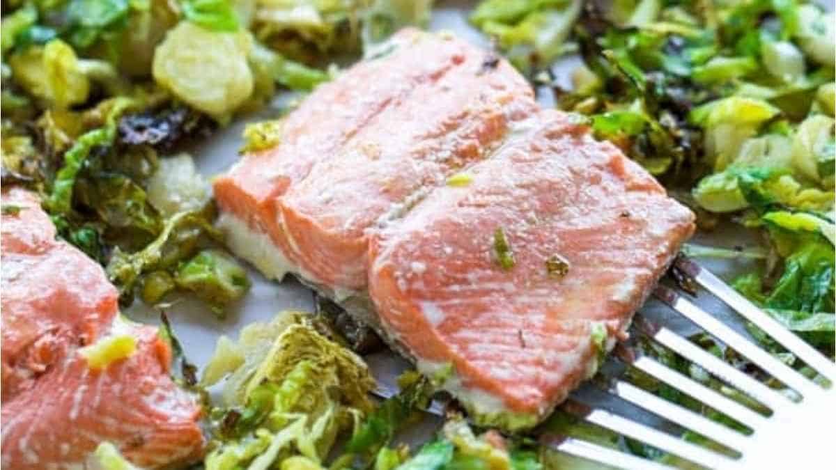 A piece of salmon with broccoli on a plate.