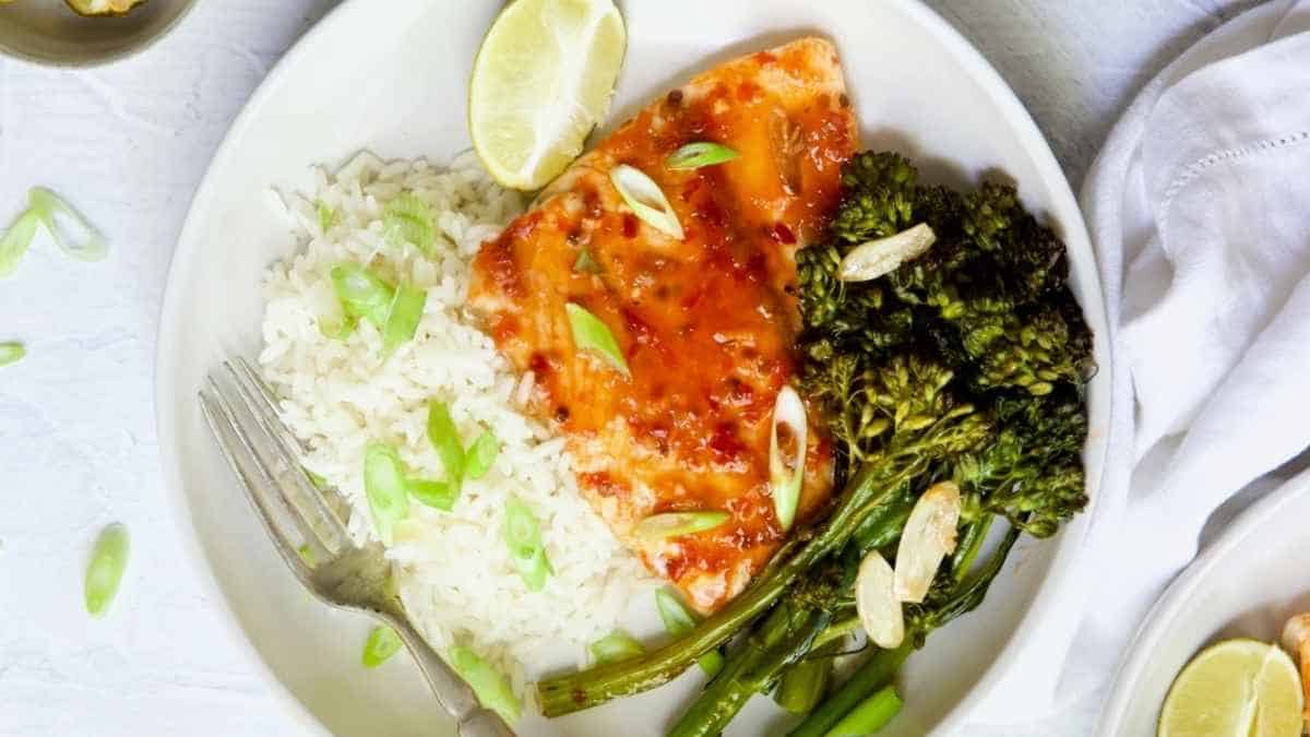A plate of salmon with broccoli and rice.