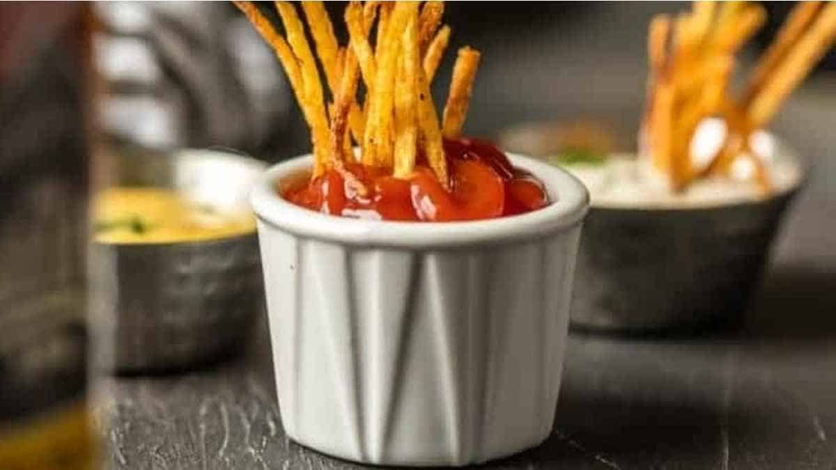 A bowl of french fries with ketchup and ketchup.