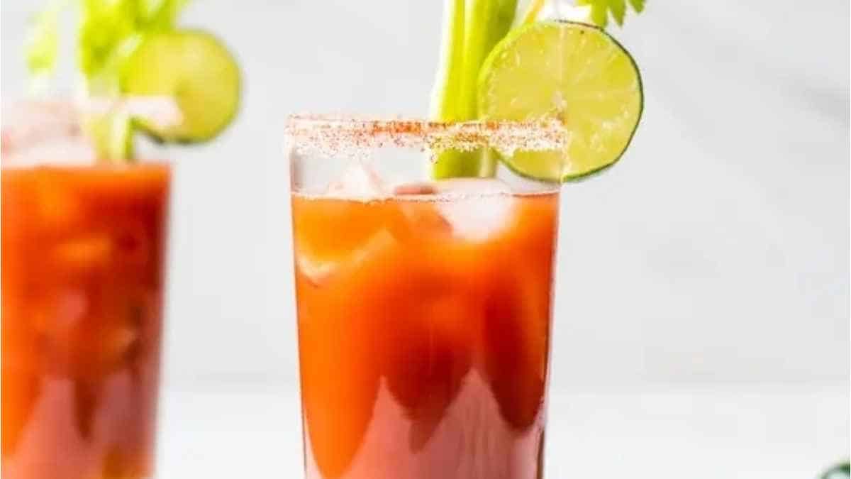 Two glasses of bloody mary with lime and celery.