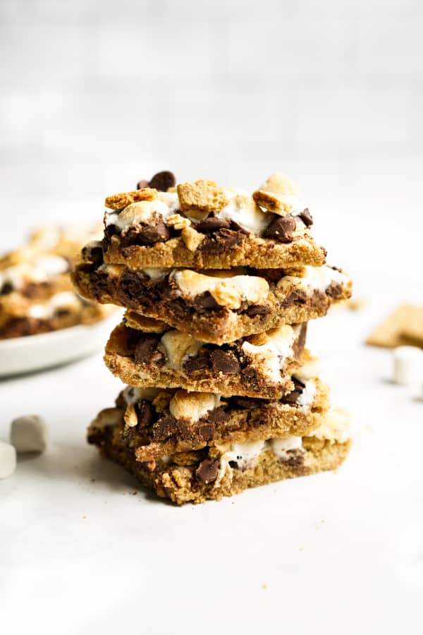 a stack of S'mores Bars with chocolate, graham crackers and marshmallow.
