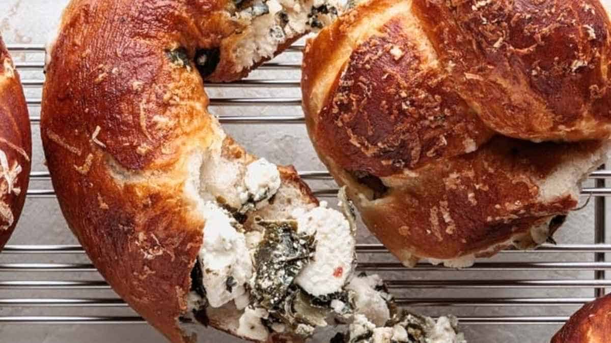 A rack of bagels with spinach and chicken on it.