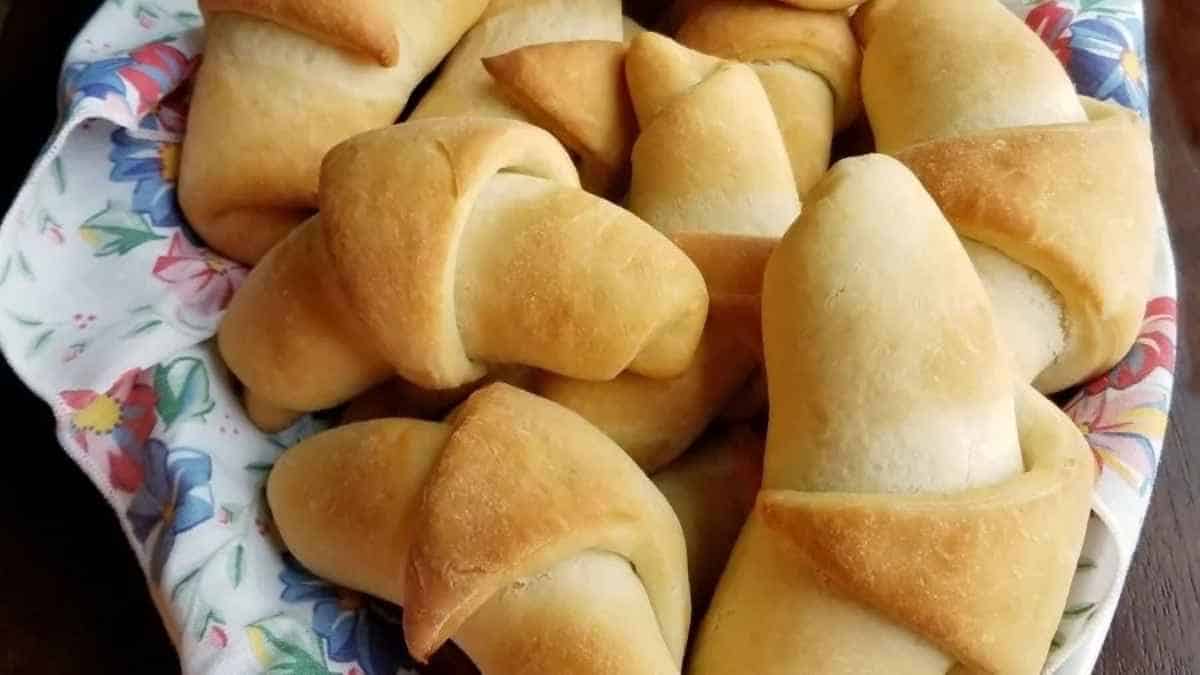 Bread rolls in a bowl on a table.