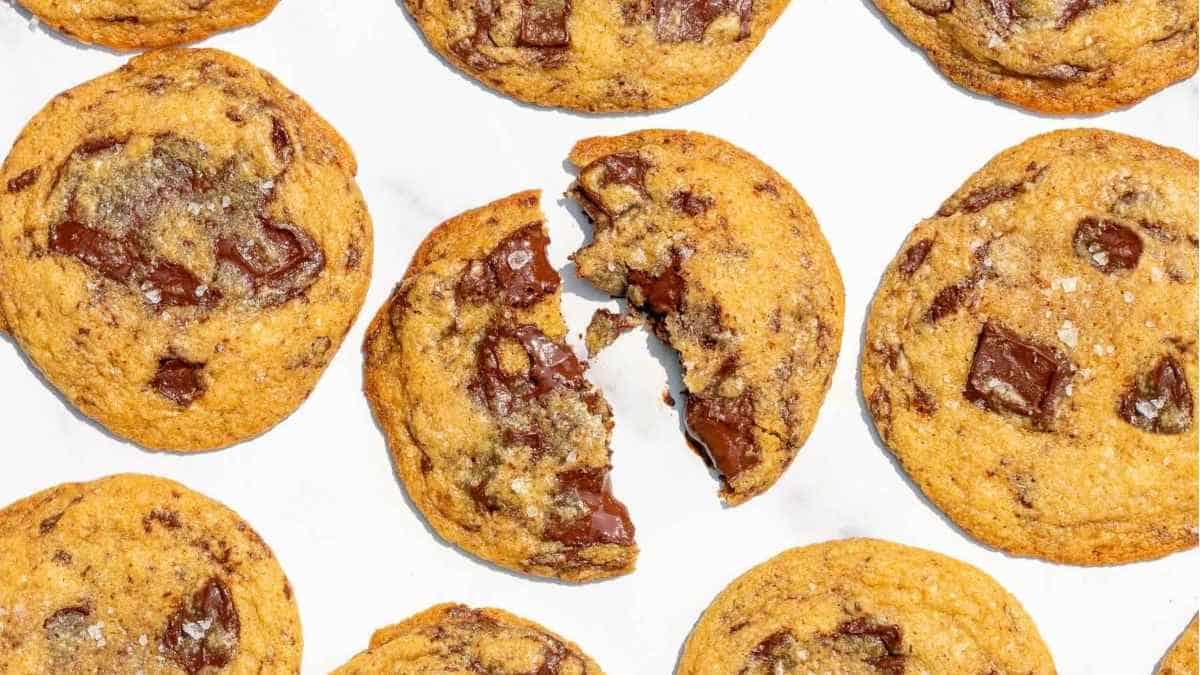 A group of chocolate chip cookies on a white surface.