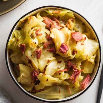 Cabbage and ham in a bowl with a fork.