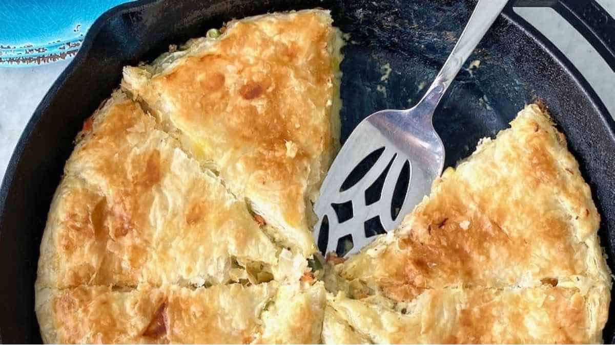 A pie in a cast iron skillet with a fork.