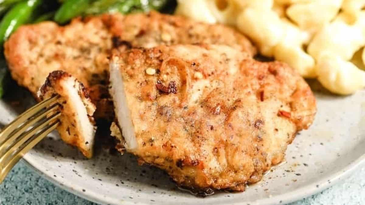 Chicken breasts and macaroni and cheese on a plate.