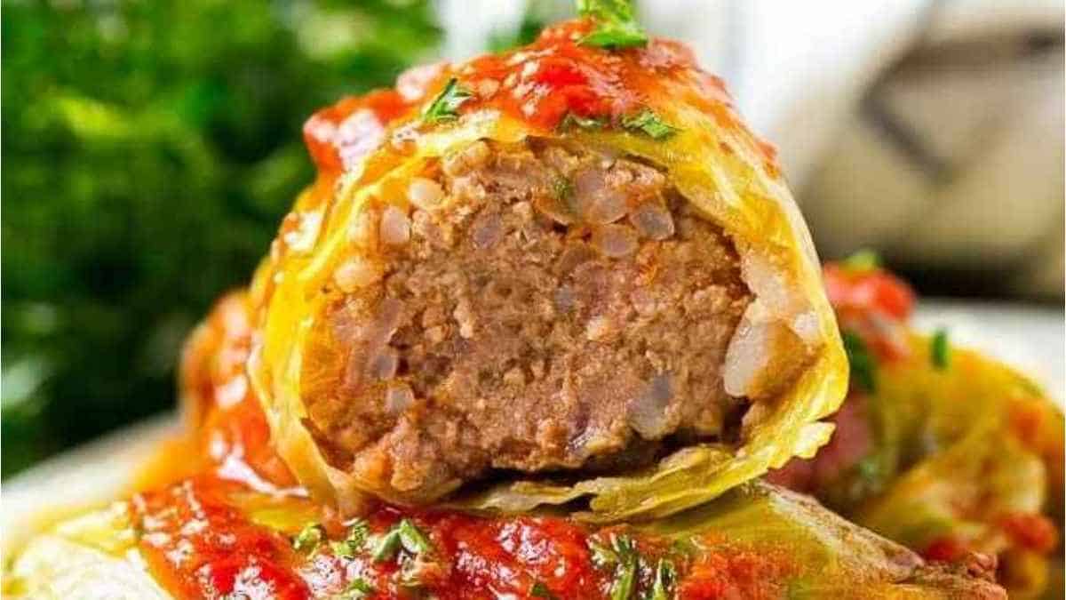 Cabbage rolls with meat and sauce on a plate.