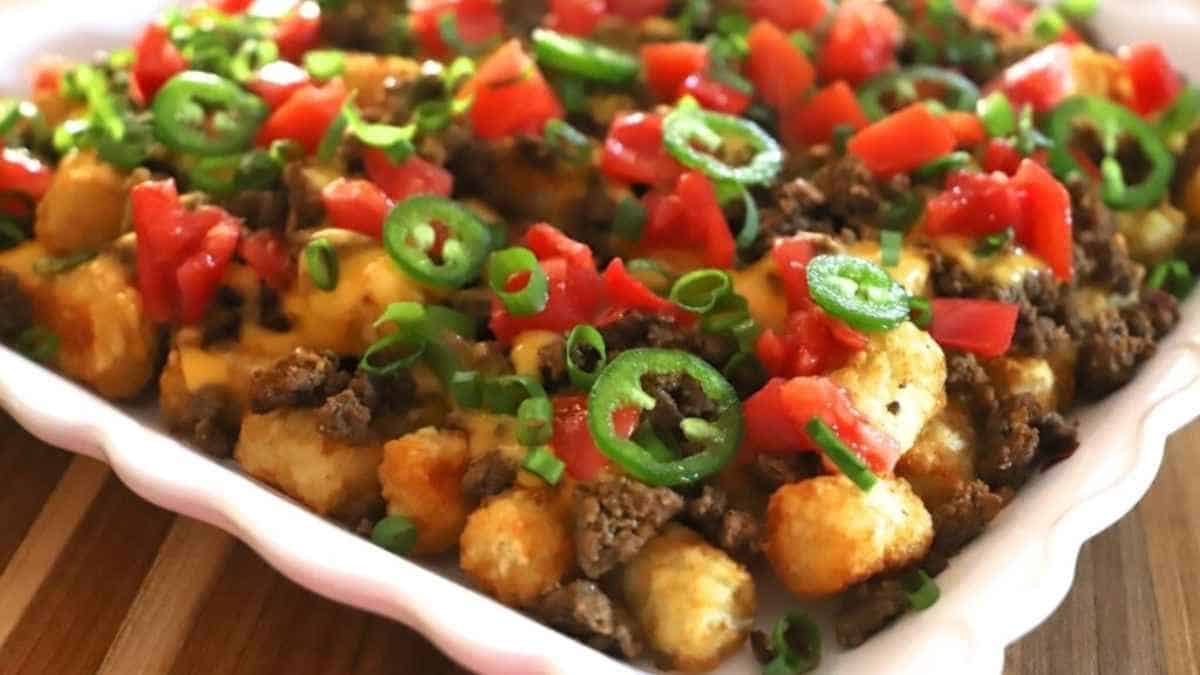 A casserole dish with meat, tomatoes, onions and green peppers.