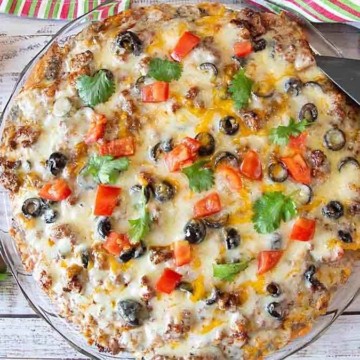 Mexican pizza in a glass dish with a knife.