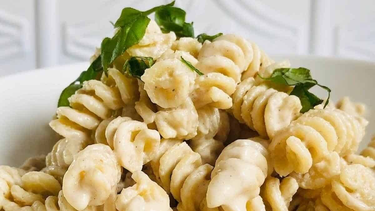 A bowl of pasta with parsley and parmesan cheese.