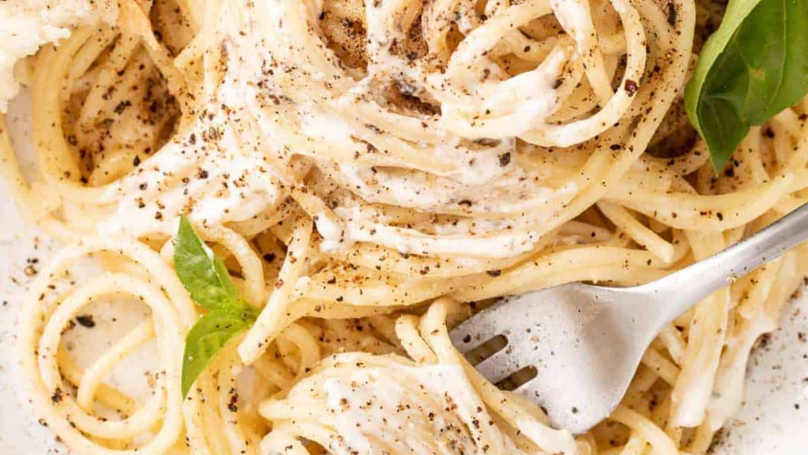 A plate of spaghetti with sauce and a fork.