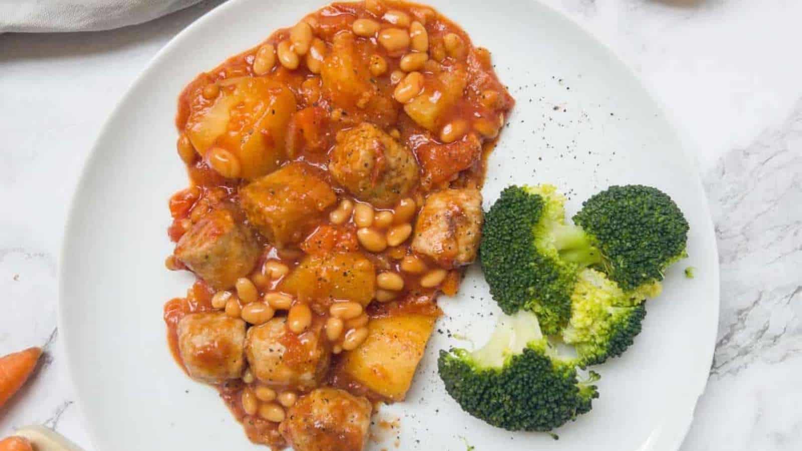 A white plate with beans, potatoes and broccoli.