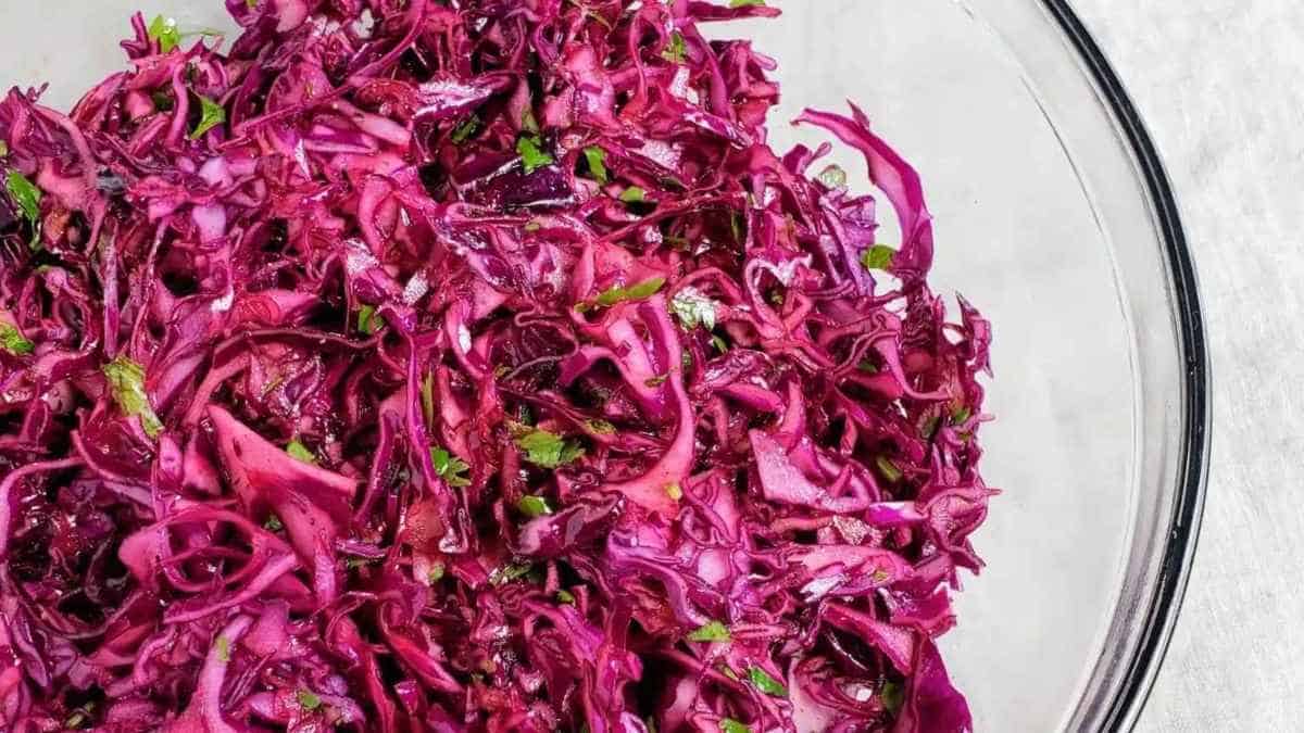 Red cabbage slaw in a glass bowl.