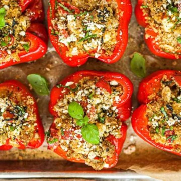 Stuffed red peppers on a baking sheet.