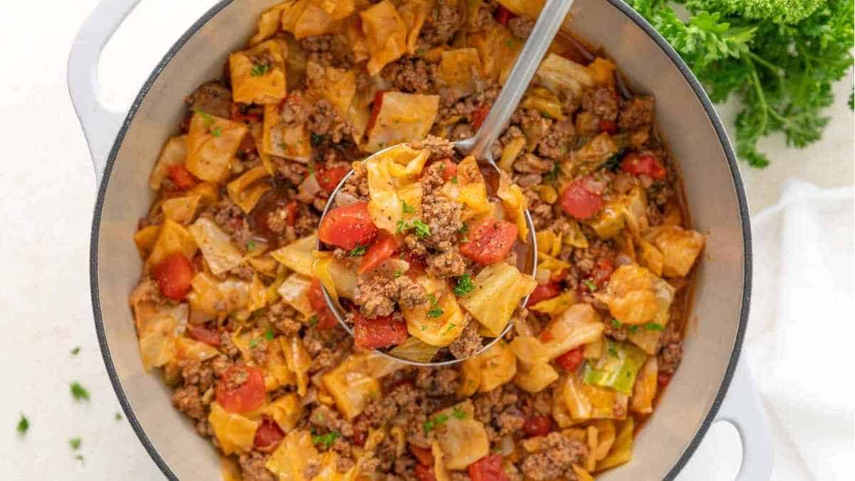 A skillet full of pasta with meat and vegetables.
