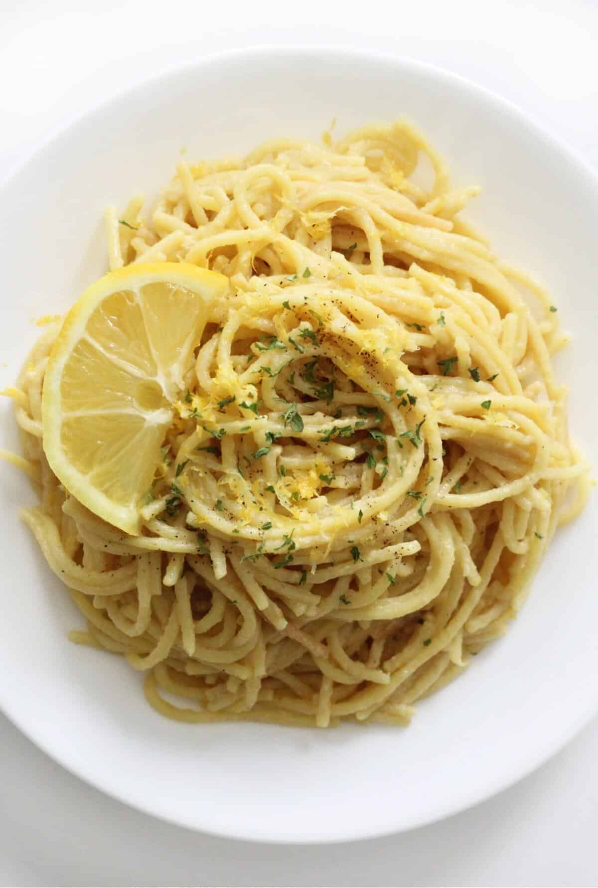 overhead view of vegan pasta al limone on white plate.
