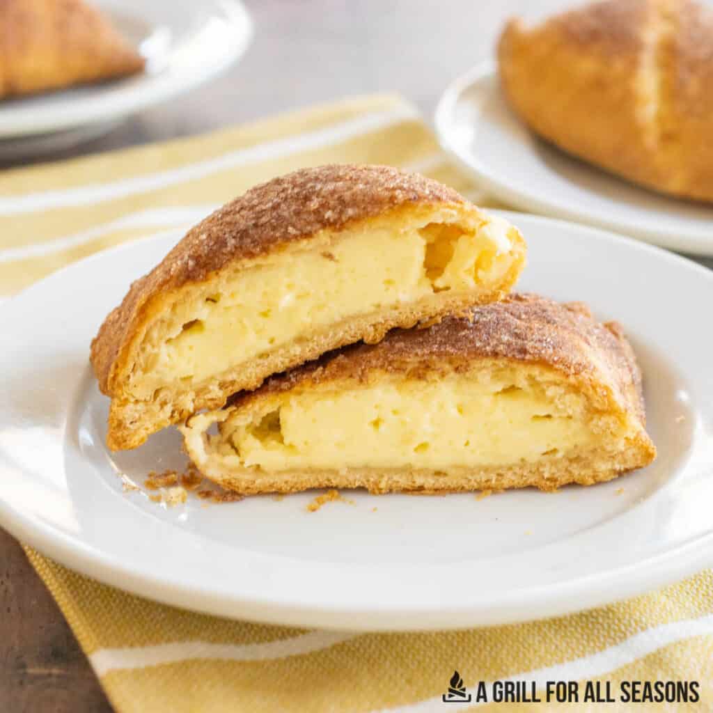 air fryer cheesecake pastries cut in half on a plate.
