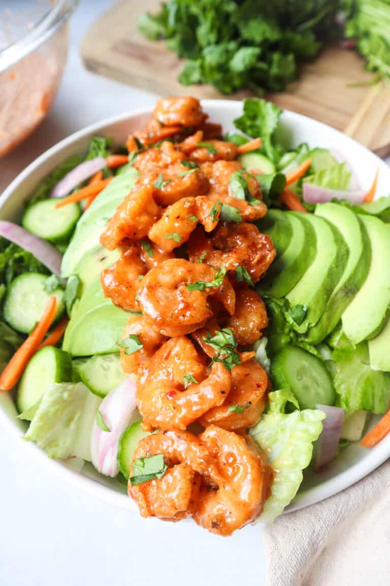 A salad with shrimp and avocado on top.