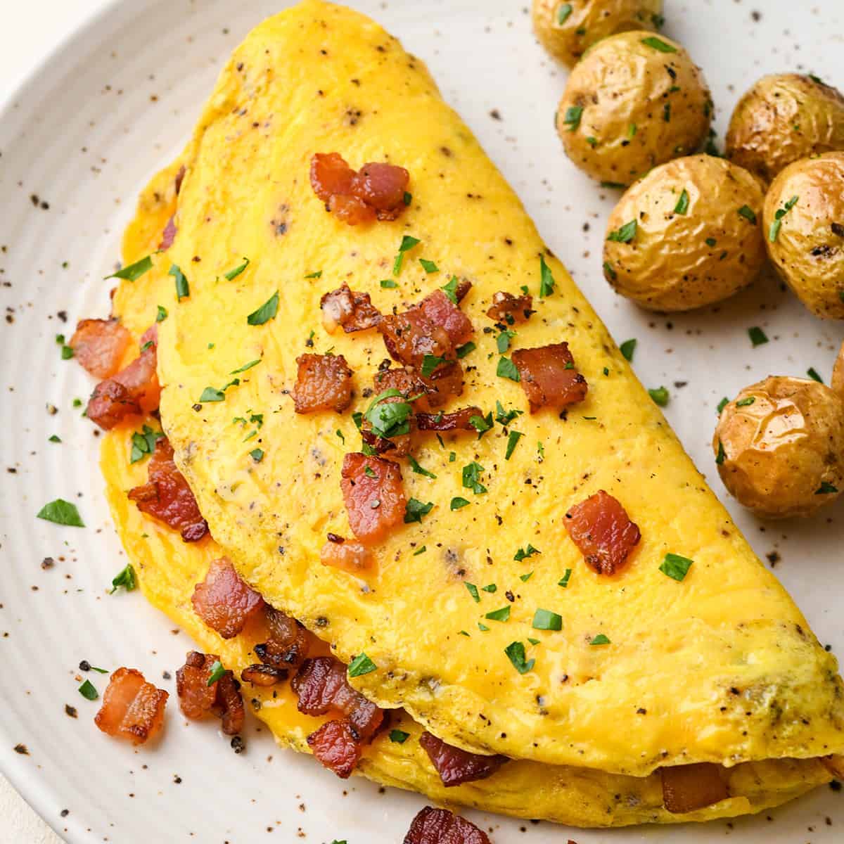 A high protein omelet with bacon and potatoes on a plate.