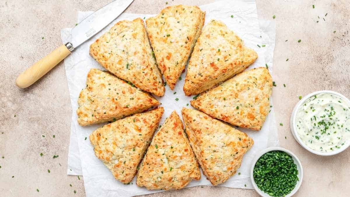 Scones are arranged in a circle with a knife and parsley.