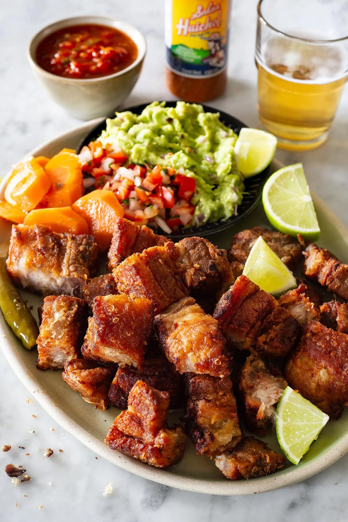 A plate of shredded pork belly with guacamole.