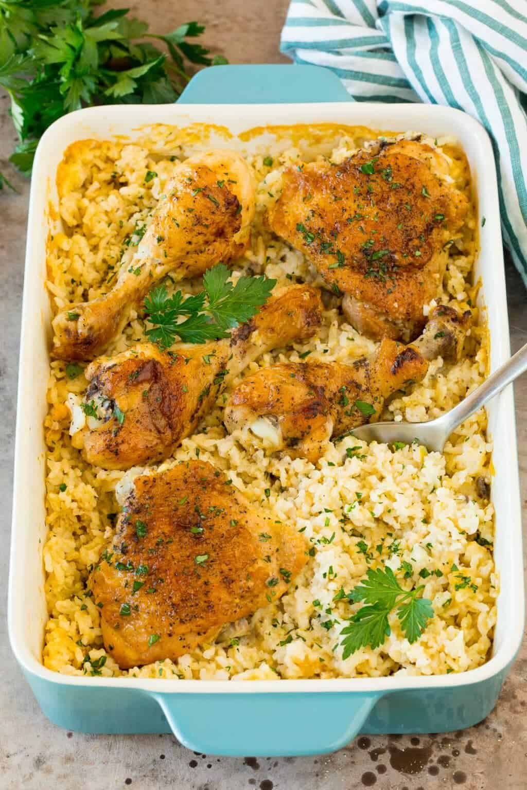 A dish of chicken and rice casserole with a serving spoon in it. 
