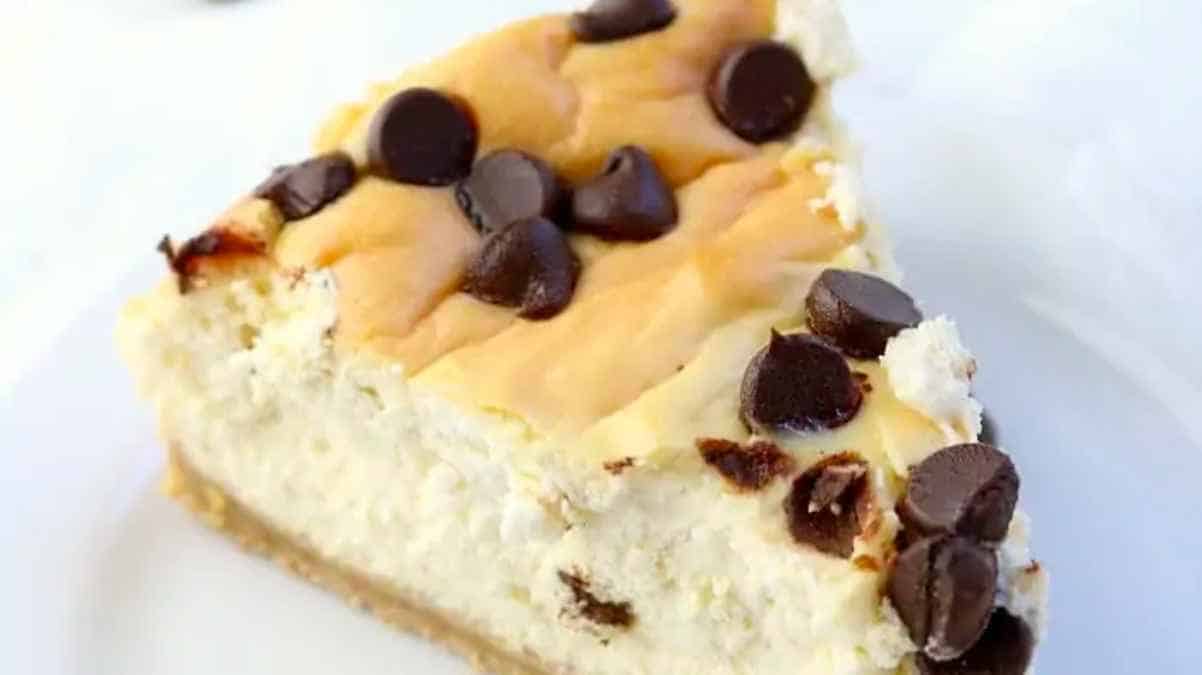 A slice of chocolate chip cheesecake on a white plate.
