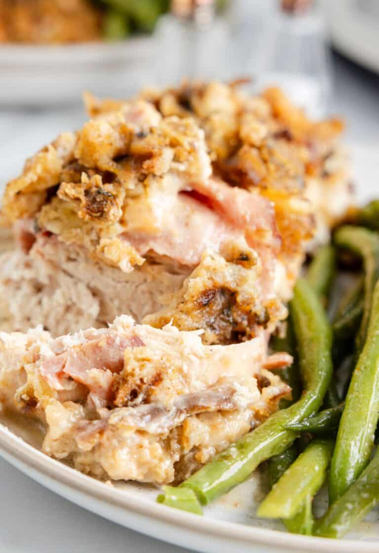 Hero shot of chicken breasts with ham and cheese with green beans next to it. 
