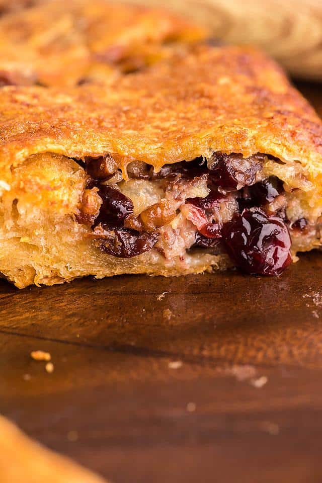 A piece of pie with cranberries and walnuts.