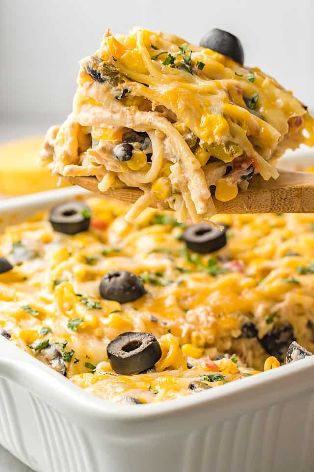 Mexican lasagna being taken out of a casserole dish.