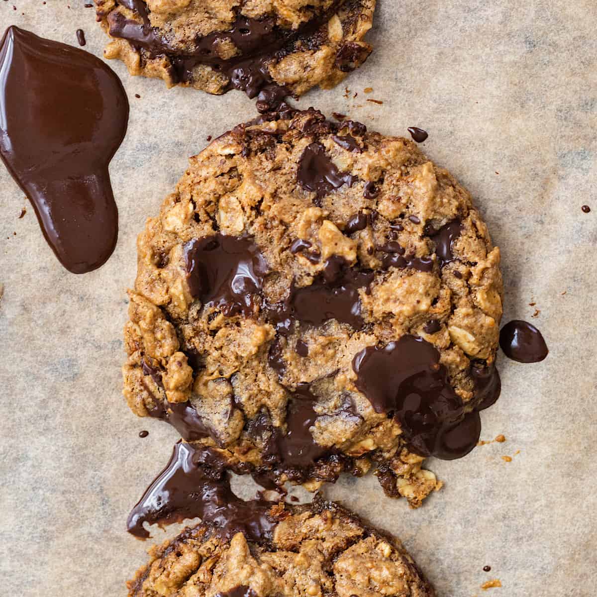 Unique chocolate oatmeal cookies with a delightful chocolate drizzle on a baking sheet.