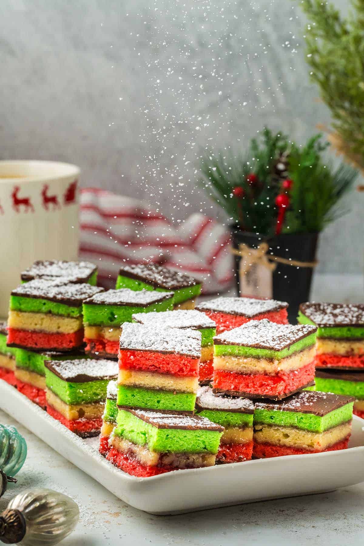 Italian Christmas cookies on a white plate with green, red, and blue decorations. 
