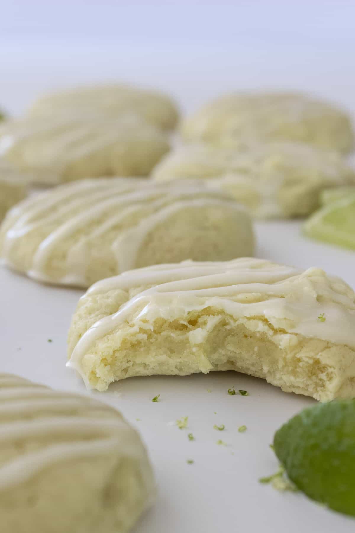 Unique lime cookies with icing on a white plate.