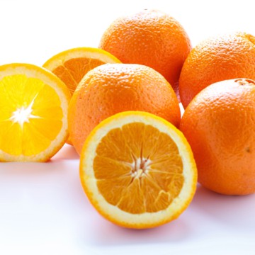 A bunch of nutritious oranges on a white surface.