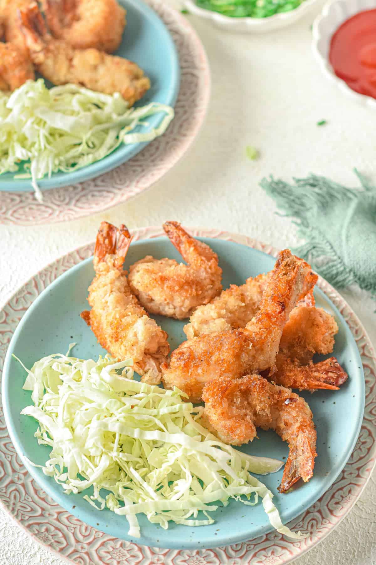 A plate of shrimp and coleslaw on a table.