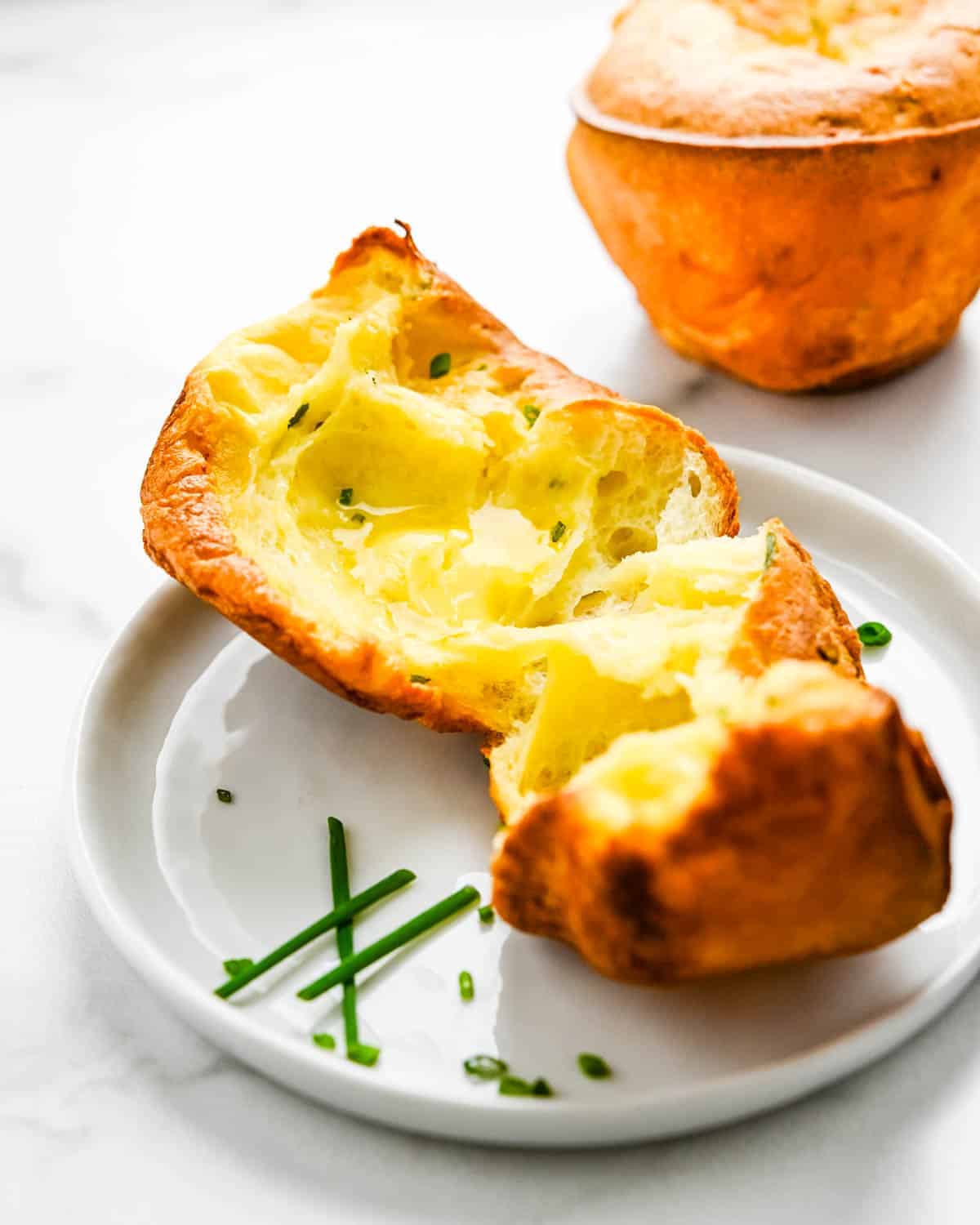 Breaking open a popover and adding butter to melt. 
