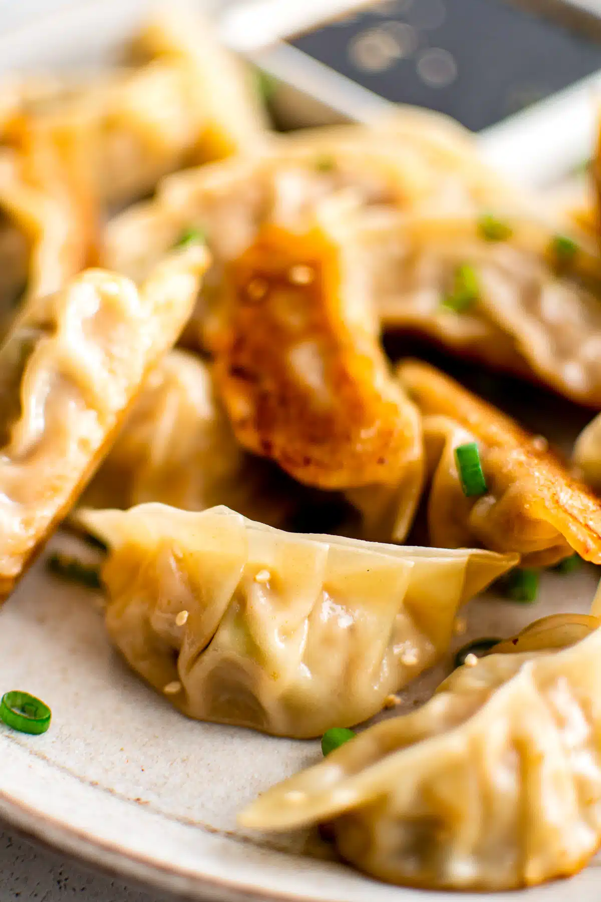 Fried dumplings on a plate with dipping sauce.