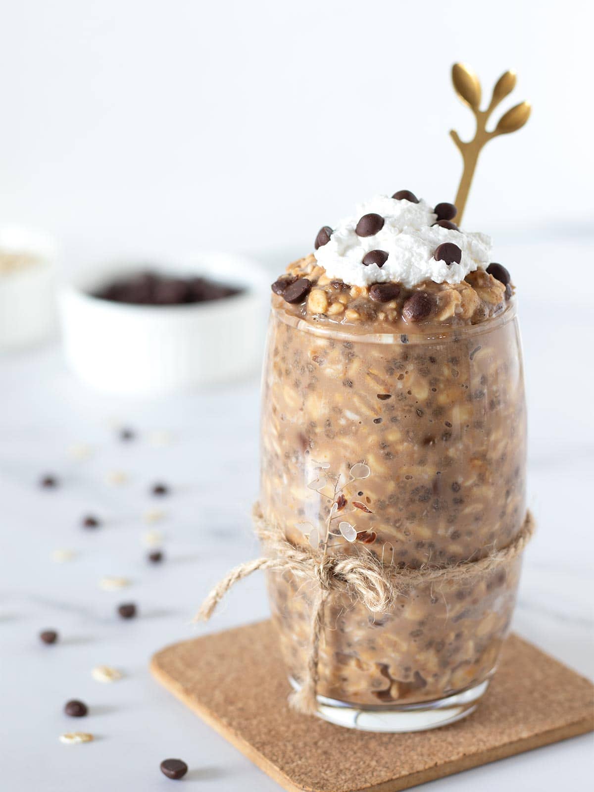 Healthy protein chocolate chip cookie dough overnight oats without yogurt topped with whipped cream in a glass. 
